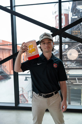 Gideon Sink holding a bag of ballpark popcorn, on the concourse of a stadium
